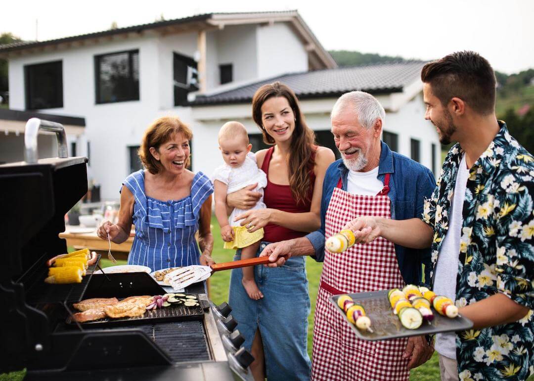 A multigenerational family outdoors grilling.