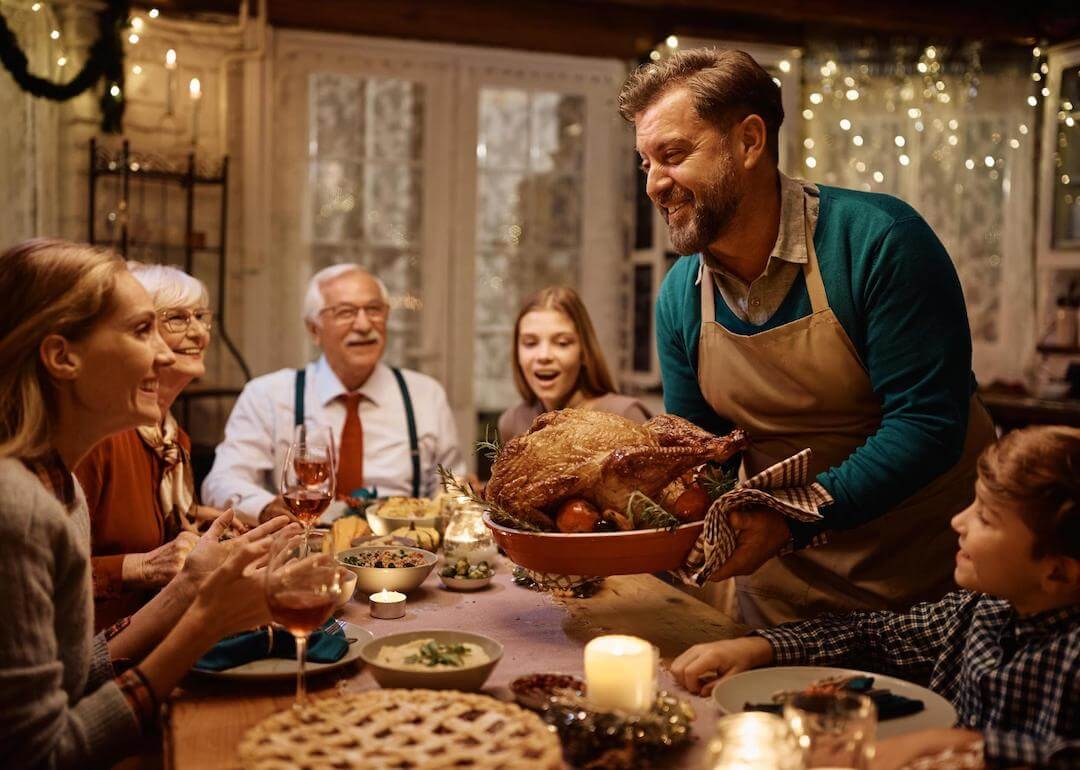 #6. Maryland Happy man bringing roast turkey at the table during dinner.