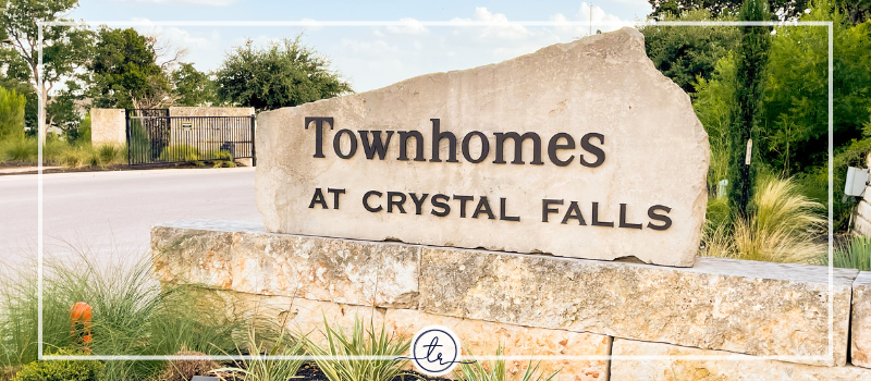 Neighborhood sign reading THE Townhomes at Crystal Falls