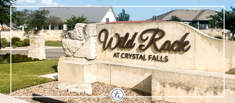 Neighborhood sign reading Wild Rock at Crystal Falls