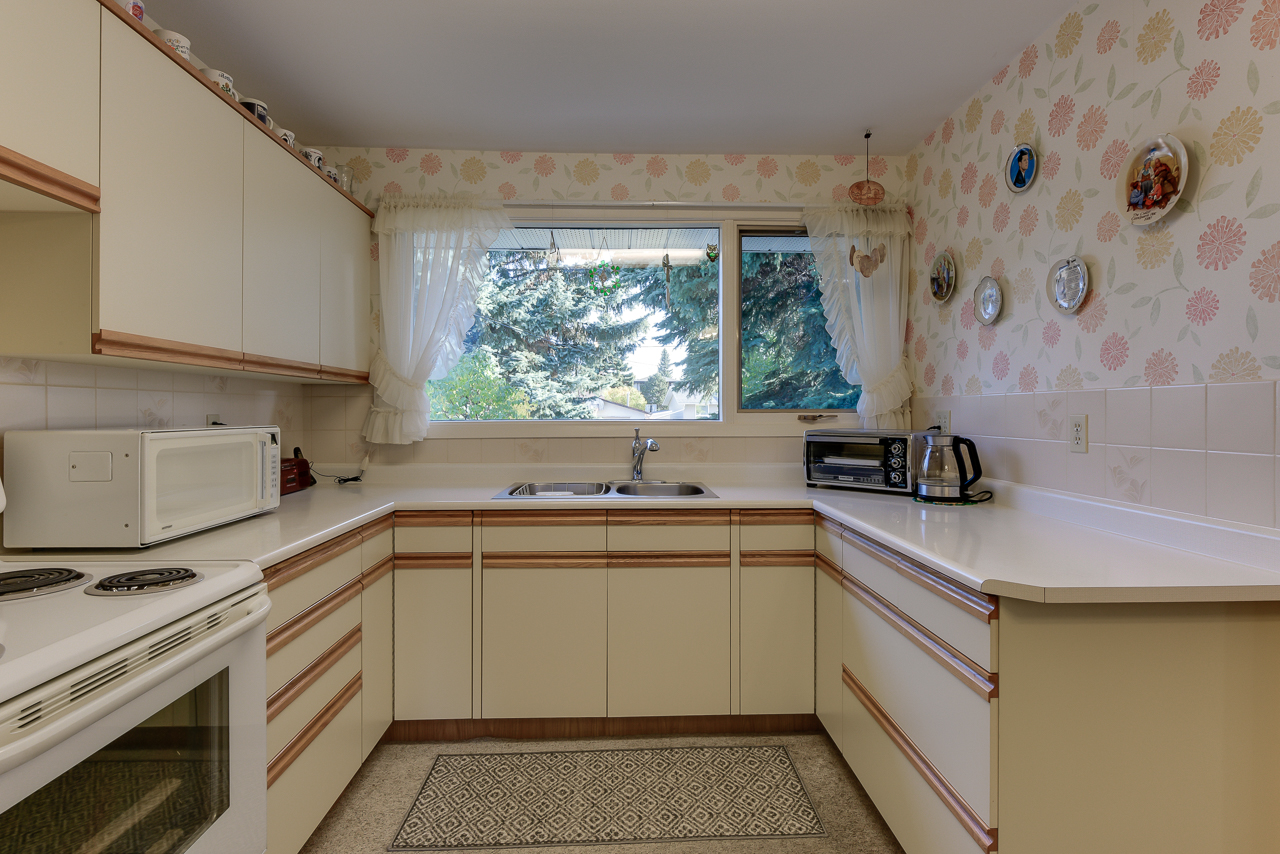 a kitchen with a stove a sink and a window