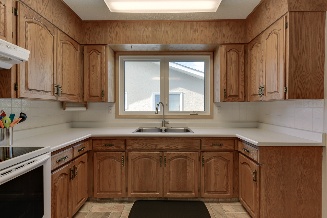 a kitchen with wooden cabinets and a microwave