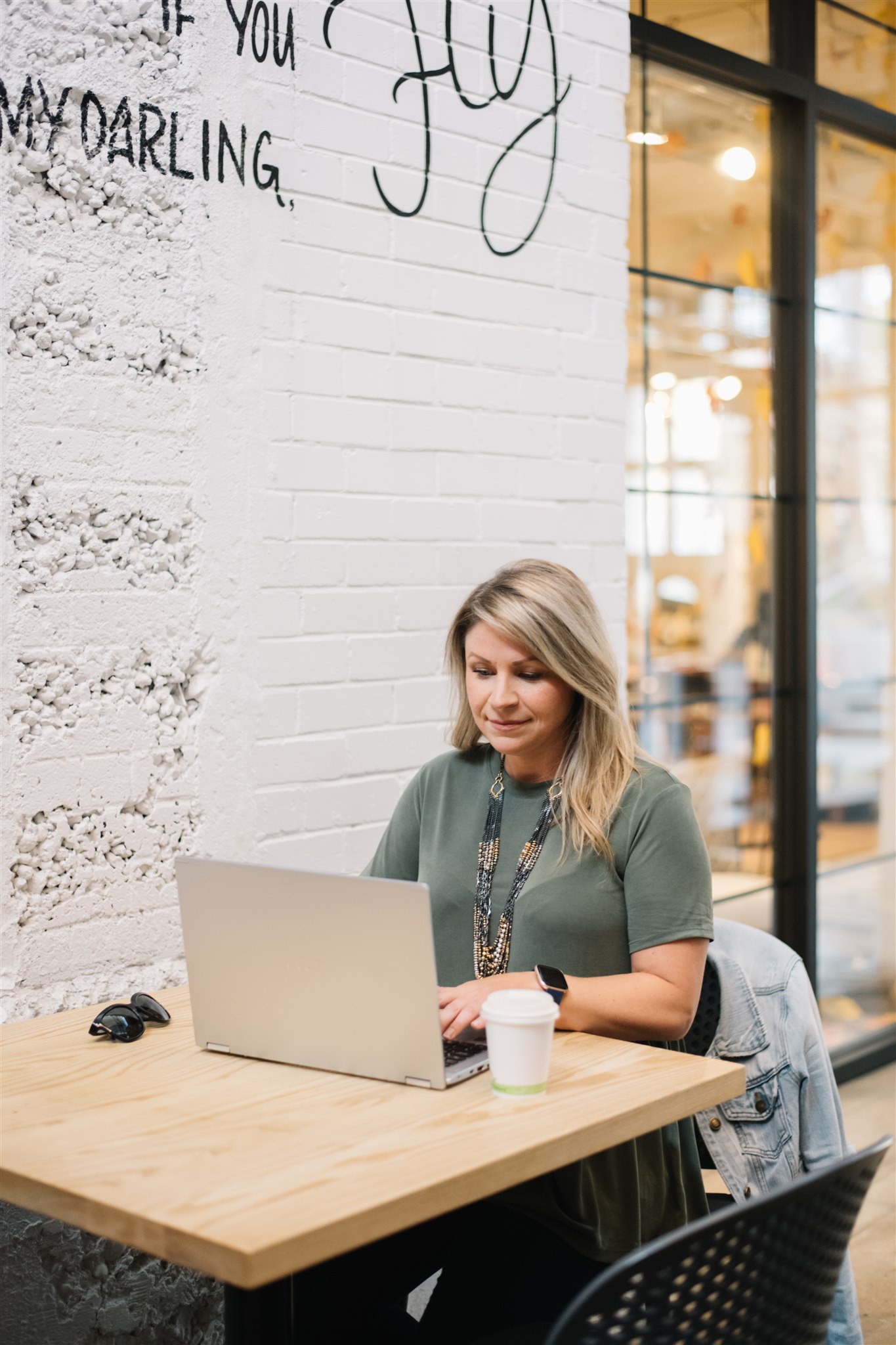 a woman sitting at a table in front of a laptop