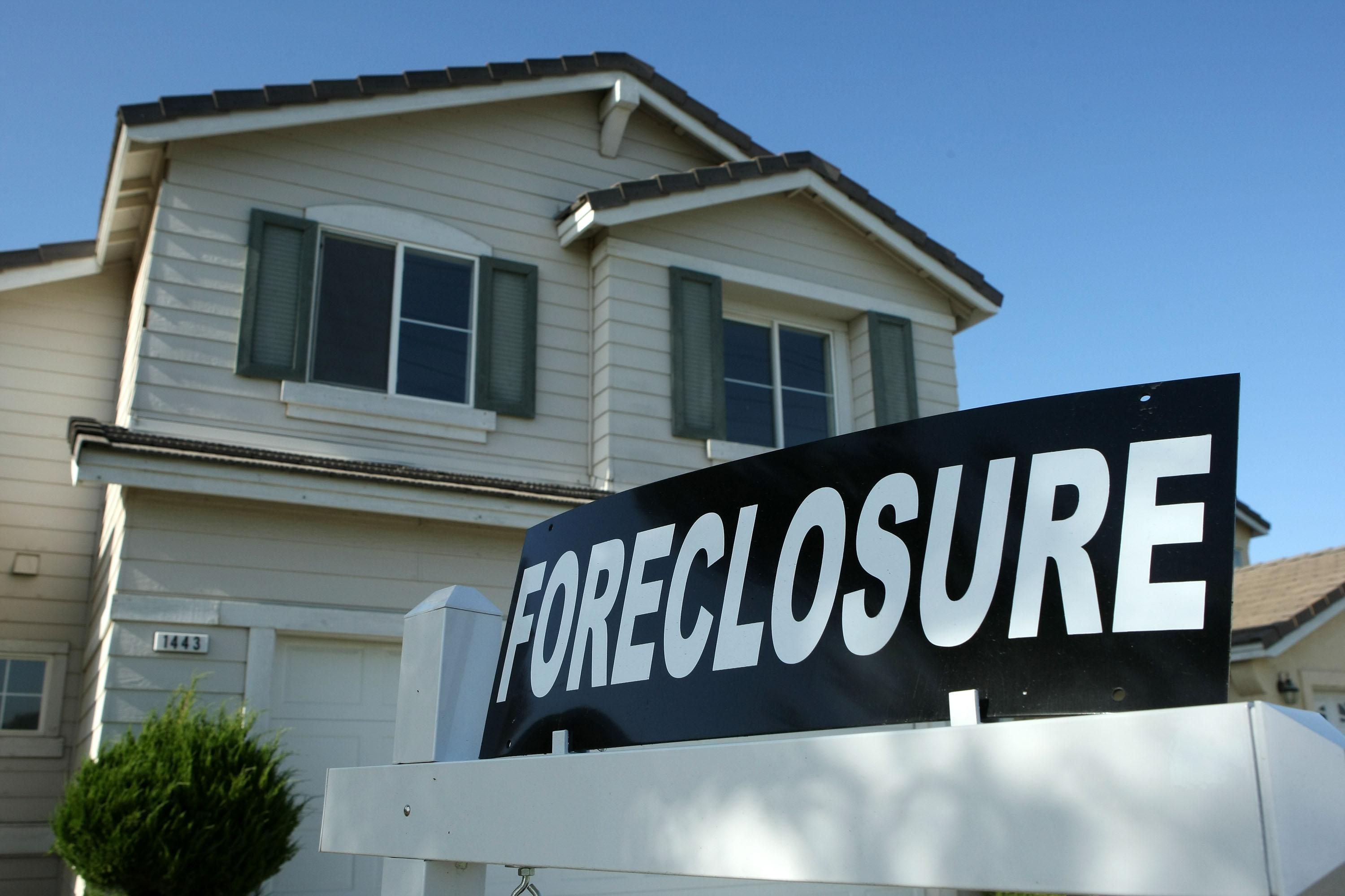 Home with a foreclosure sign in front
