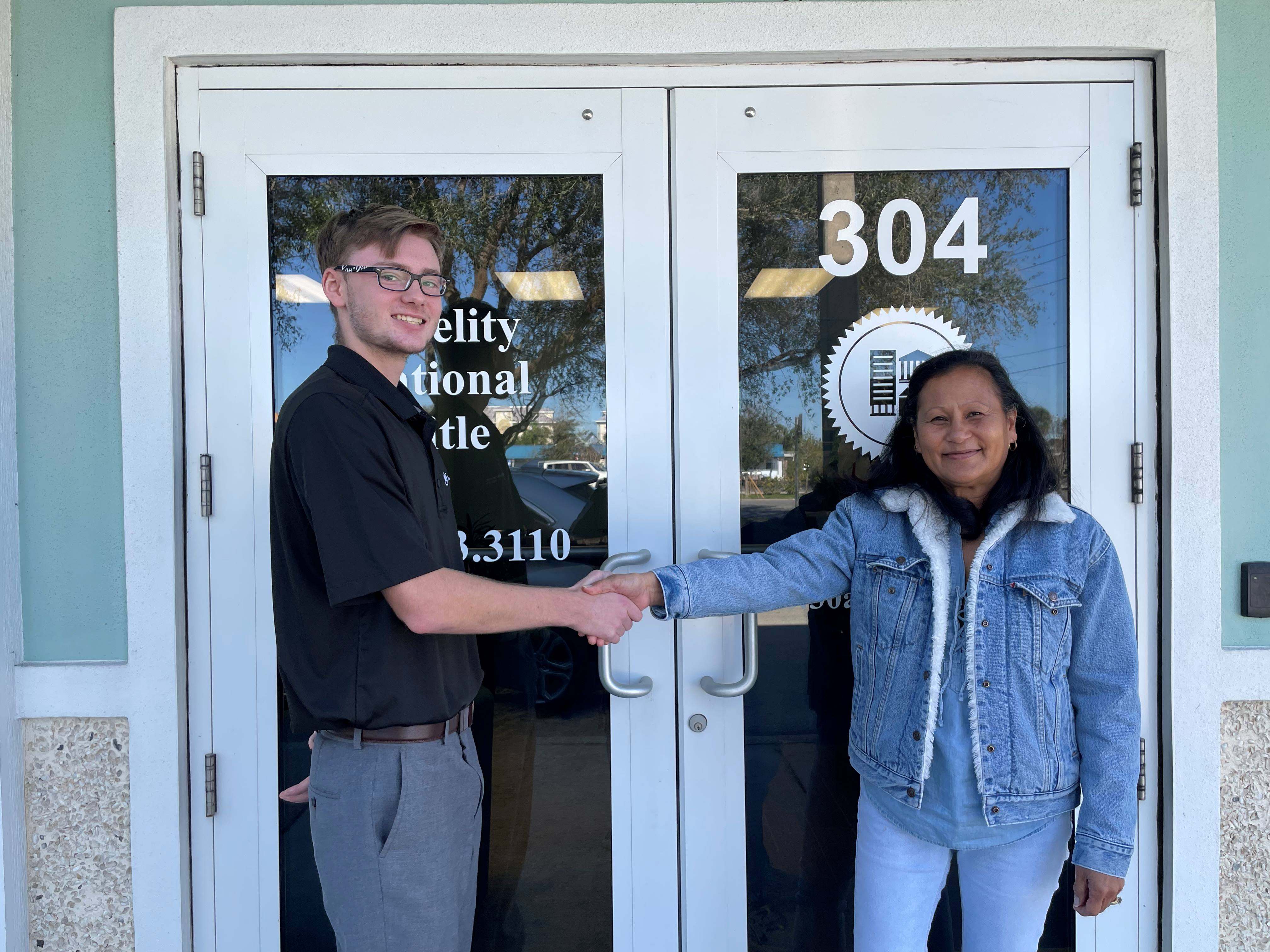 Jayden Irish at a Title Office shaking hands with his client