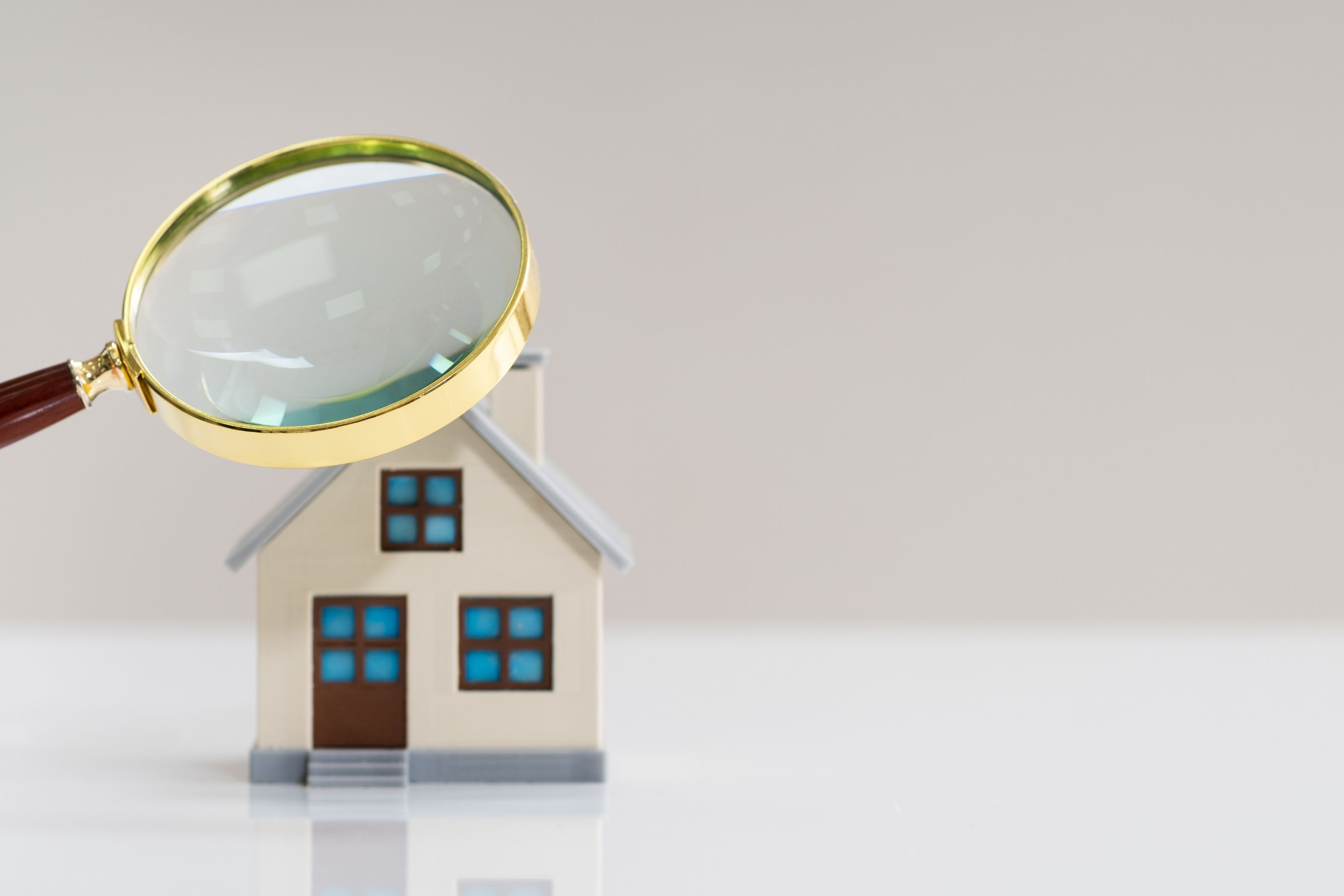 magnifying-glass-over-toy-home-representing-a-home-inspection