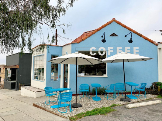 Blue building with white umbrellas at Café De Leche