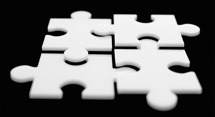 4 white puzzle pieces hover over a black background