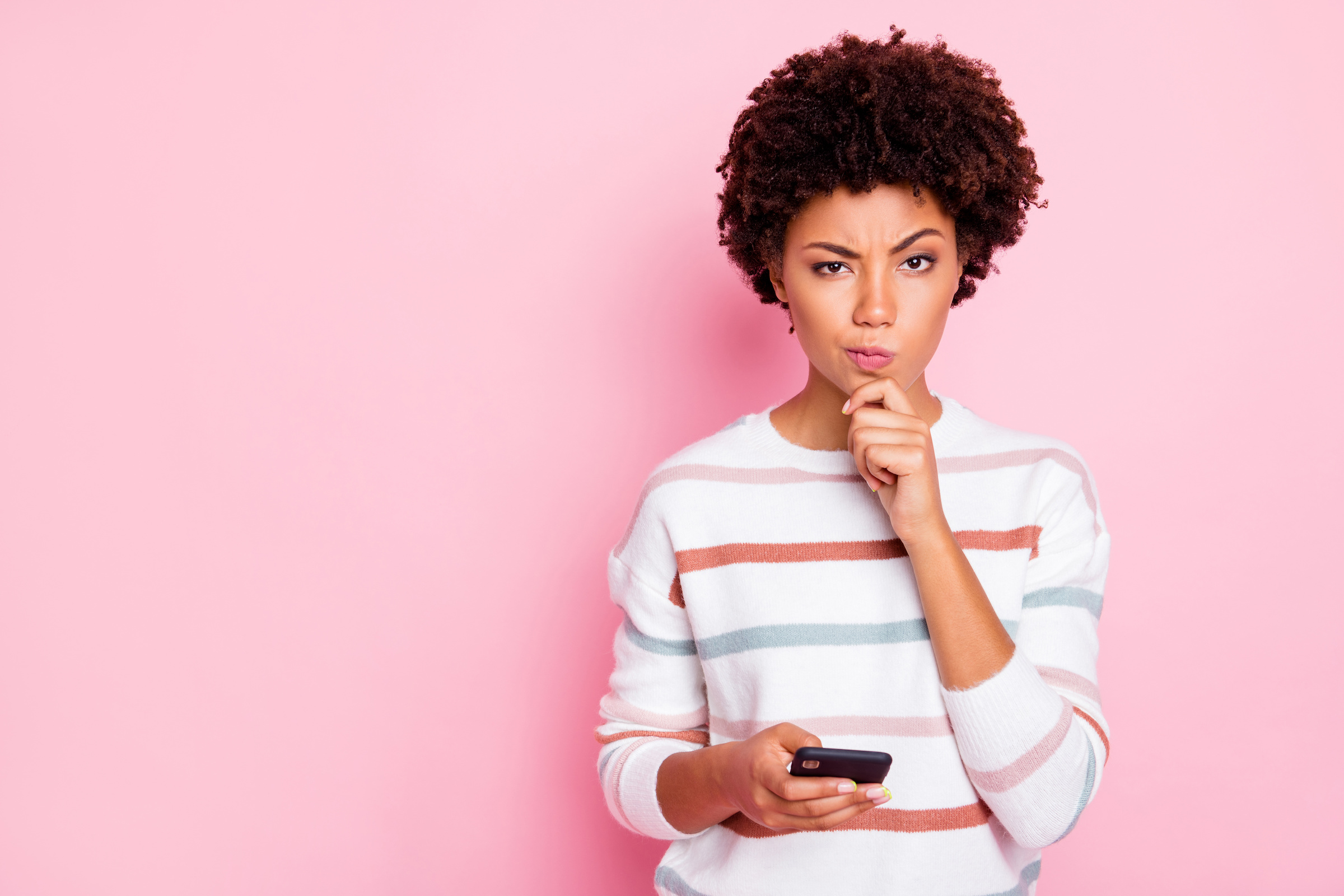 woman looking suspiciously at her phone