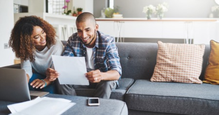 couple sitting on couch reviewing documents