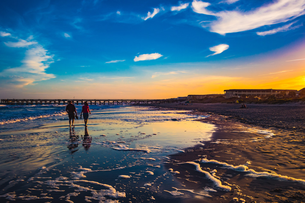 Couple walking during Sunset on Isle of Palms Beach with Pier in background