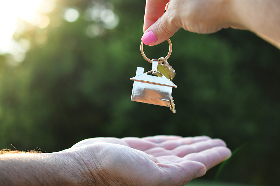real estate agent handing buyer keys to home