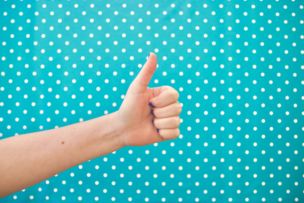 Thumbs up with polka dot background