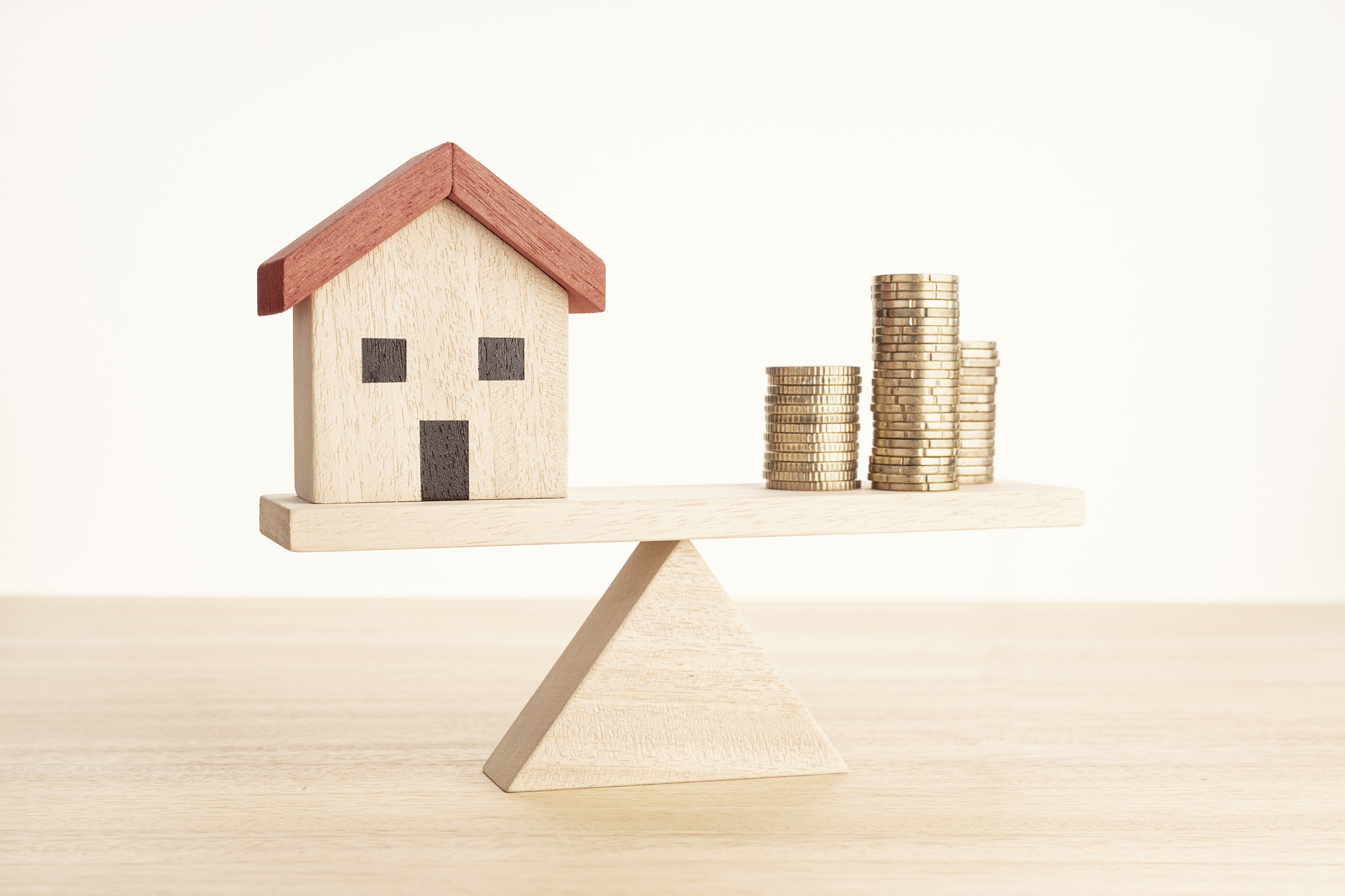 Model Charleston Home and Coins balancing on block