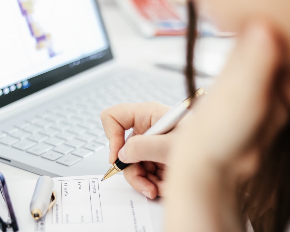 homeowner writing a check to pay Capital Gains tax in South Carolina After the sale of her Charleston real estate home