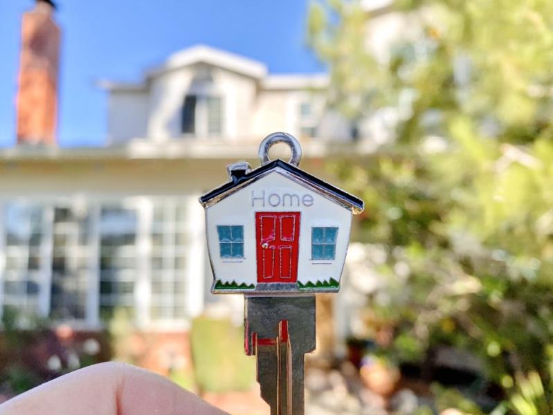 homeowner holding a key in front of their new Charleston home