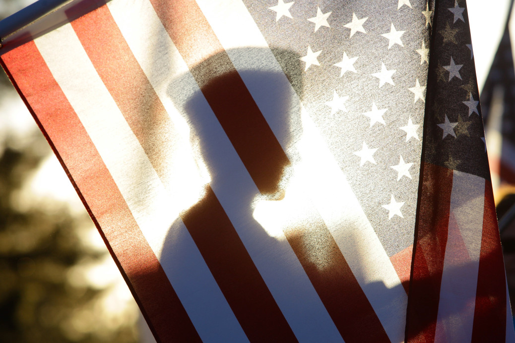 soldier standing behind american flag - VA home Loans in Charleston, SC