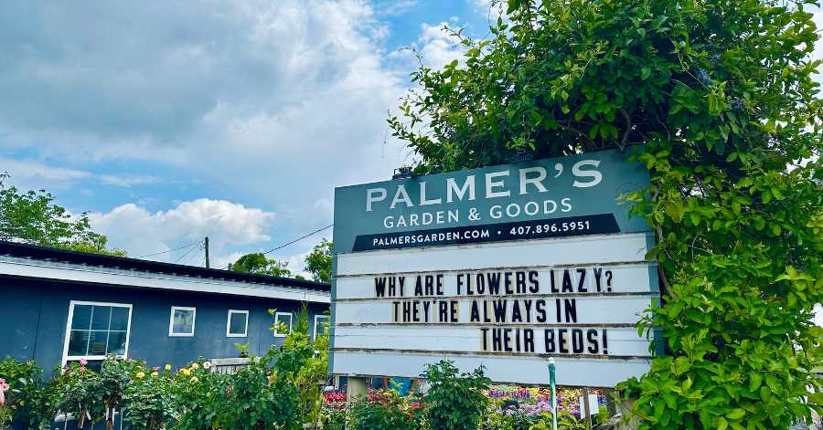 Palmer's Garden & Goods sign with a funny joke that says: "Why are flowers lazy? They're always in their beds!"