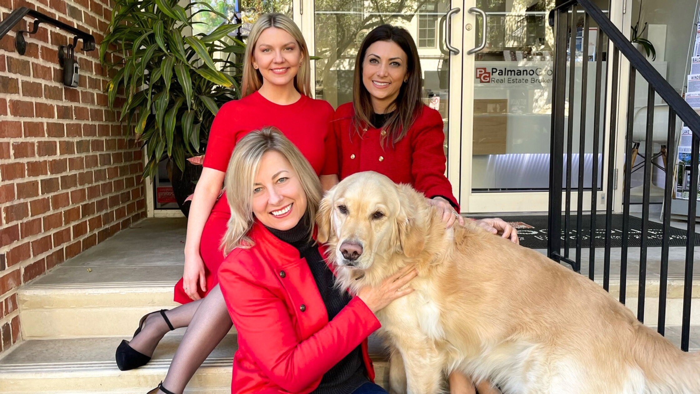 real estate agents at the office of palmano group real estate brokerage in winter park florida, their dog bruno, who is a golden retriever is sitting on the steps wiuth them