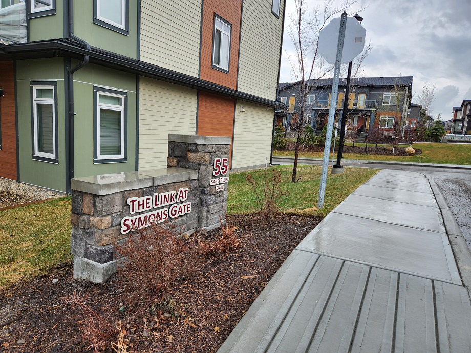 Entrance to The Link at Symons Gate featuring signage with townhomes in the background