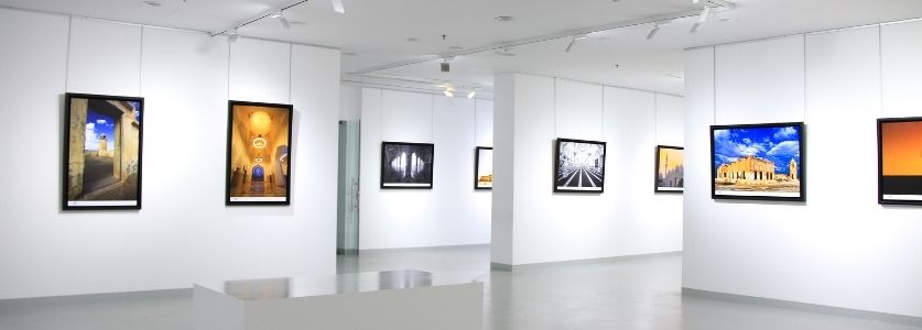 Three art pictures hanging against a white wall 
