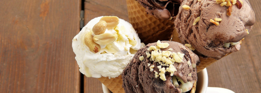Three cones with vanilla, chocolate and nuts on them 