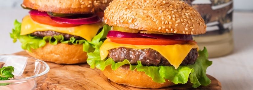 Two fluffy burgers with cheese, onions and lettuce 