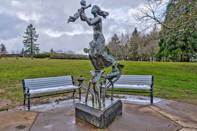Statue of a Woman Holding a Child in Front of Benches at Council Crest Park in Council Crest, Southwest Portland, Oregon