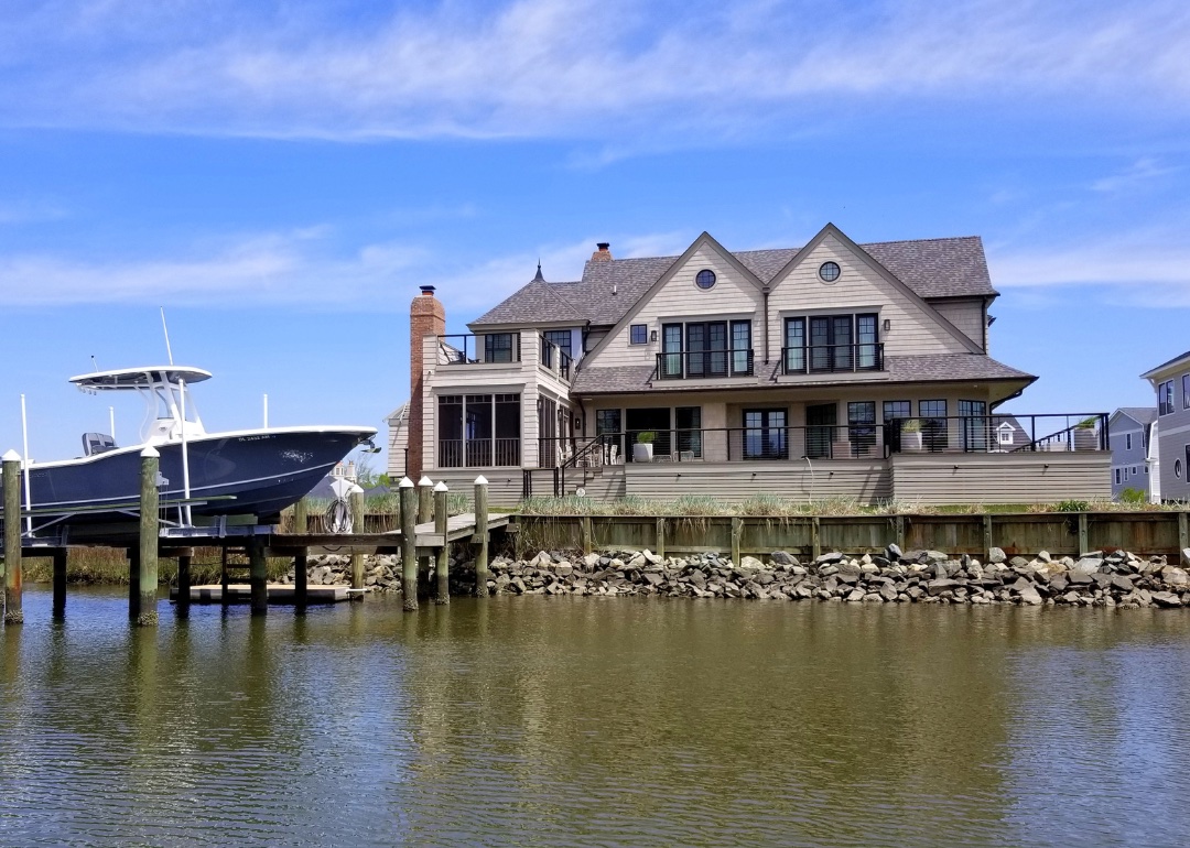 #6. Delaware Luxury, new construction waterfront homes with a boat docked by the bay in Rehoboth Beach.