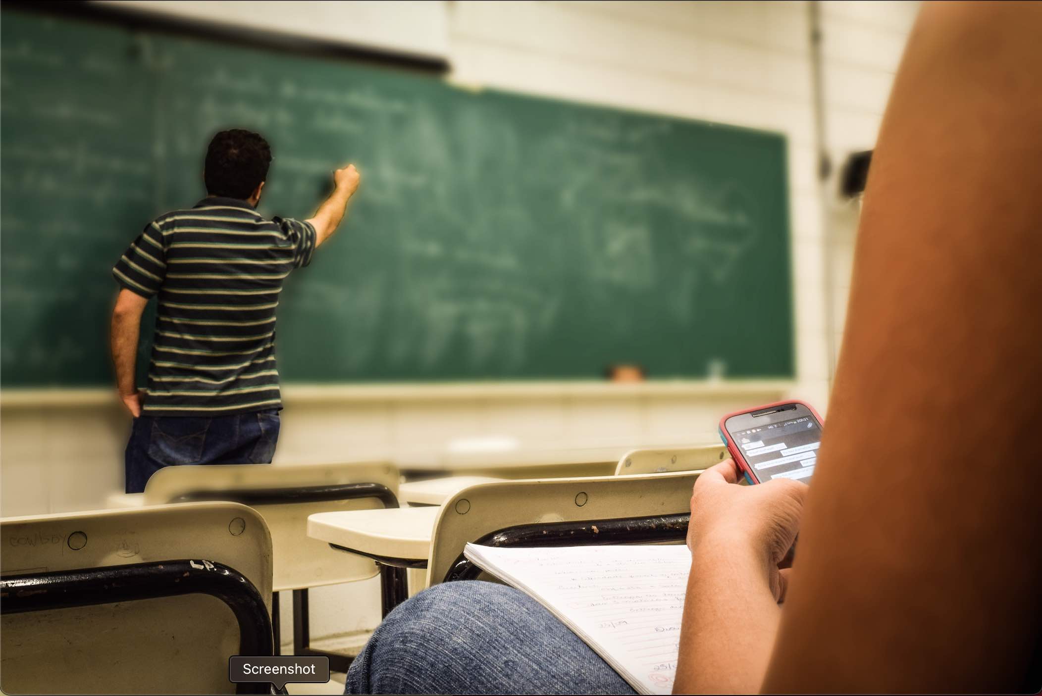 Teacher Writing on Chalkboard