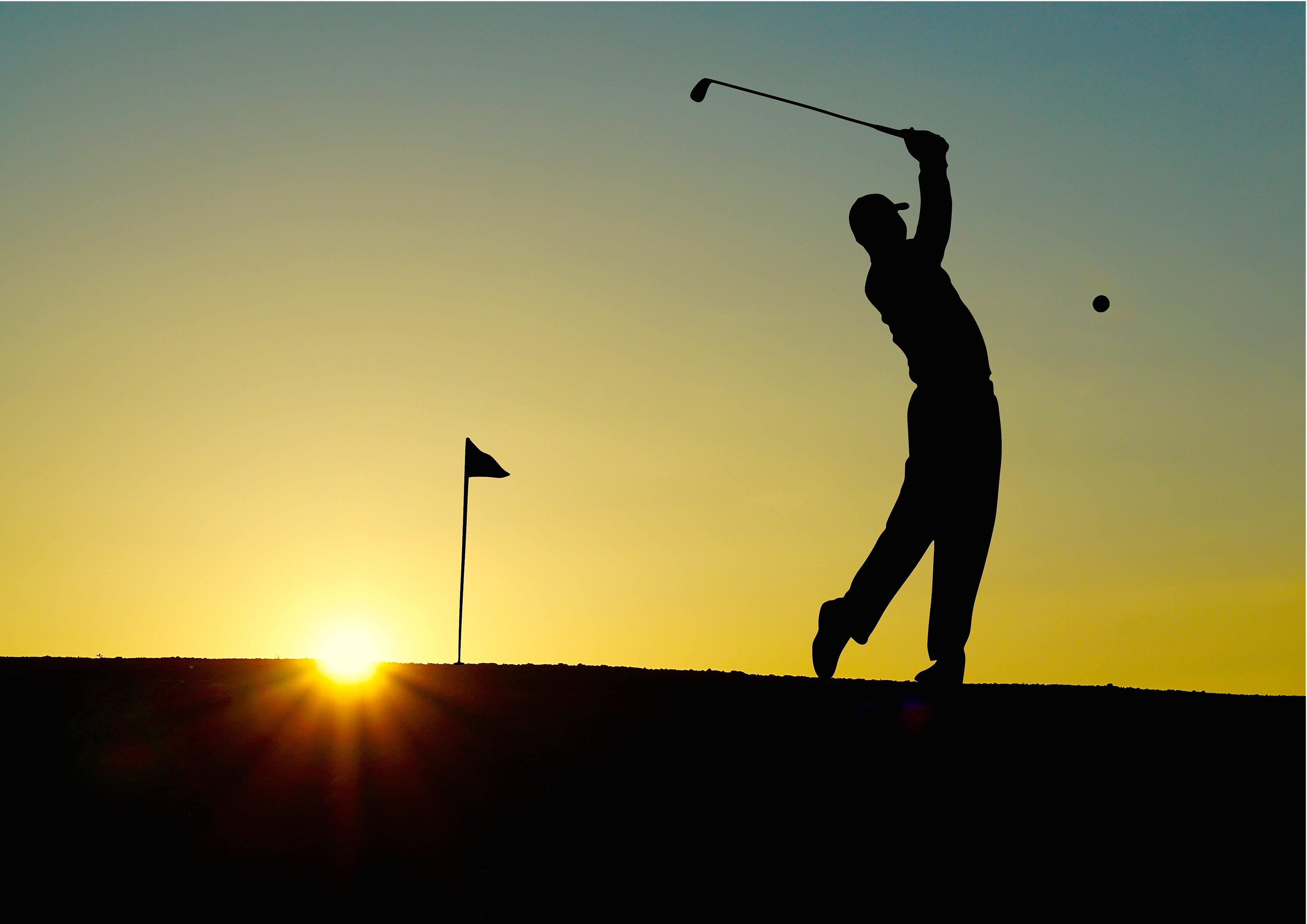 Man Playing Golf at Sunset