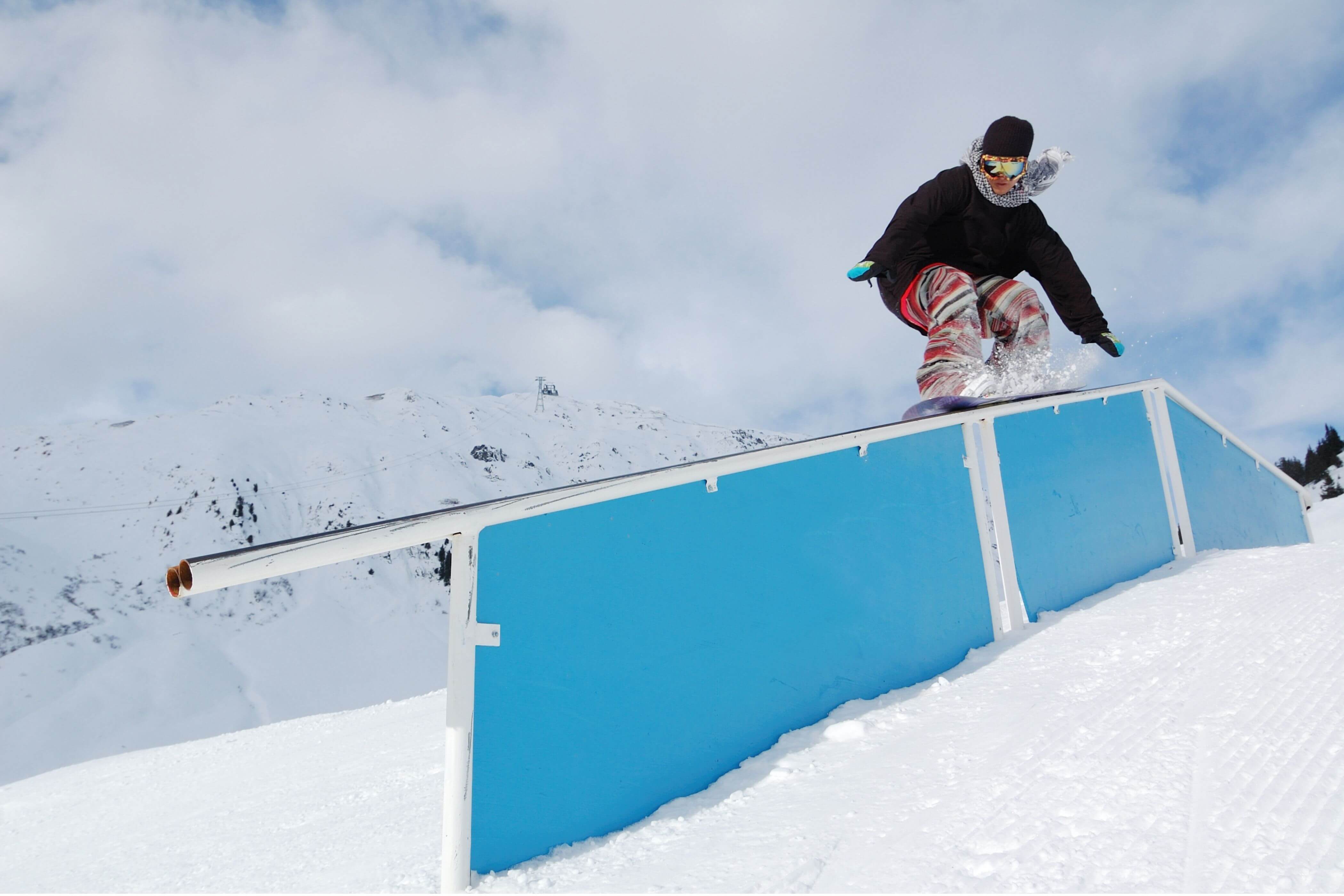 Snowboarder hitting a rail.