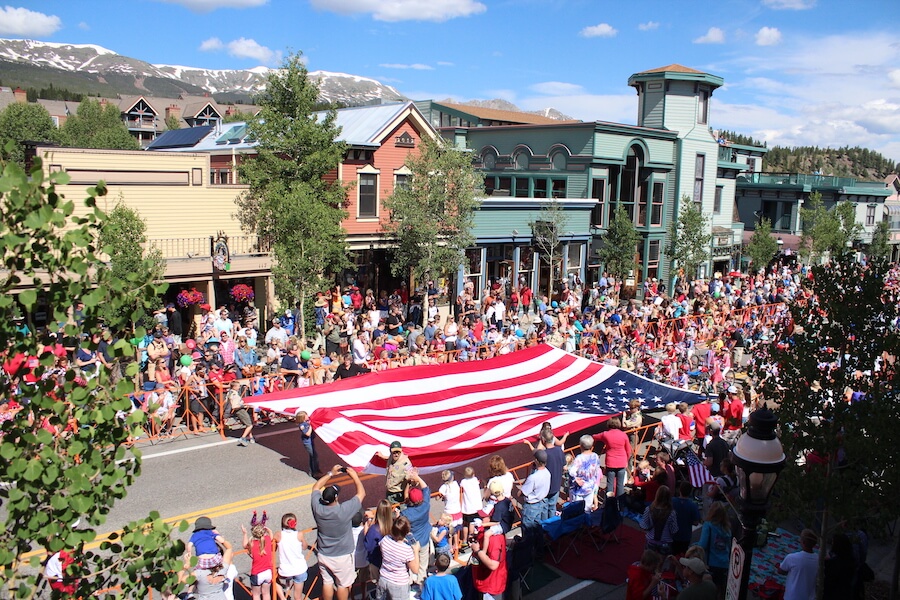 Fourth of July parade featuring boy scouts carrying large America Flag down Main Street Breckenridge