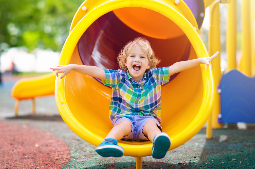 Child in a yellow slide at a Sacramento Playground