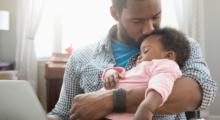 Young man holding a baby - What are the real reasons you want to move right now