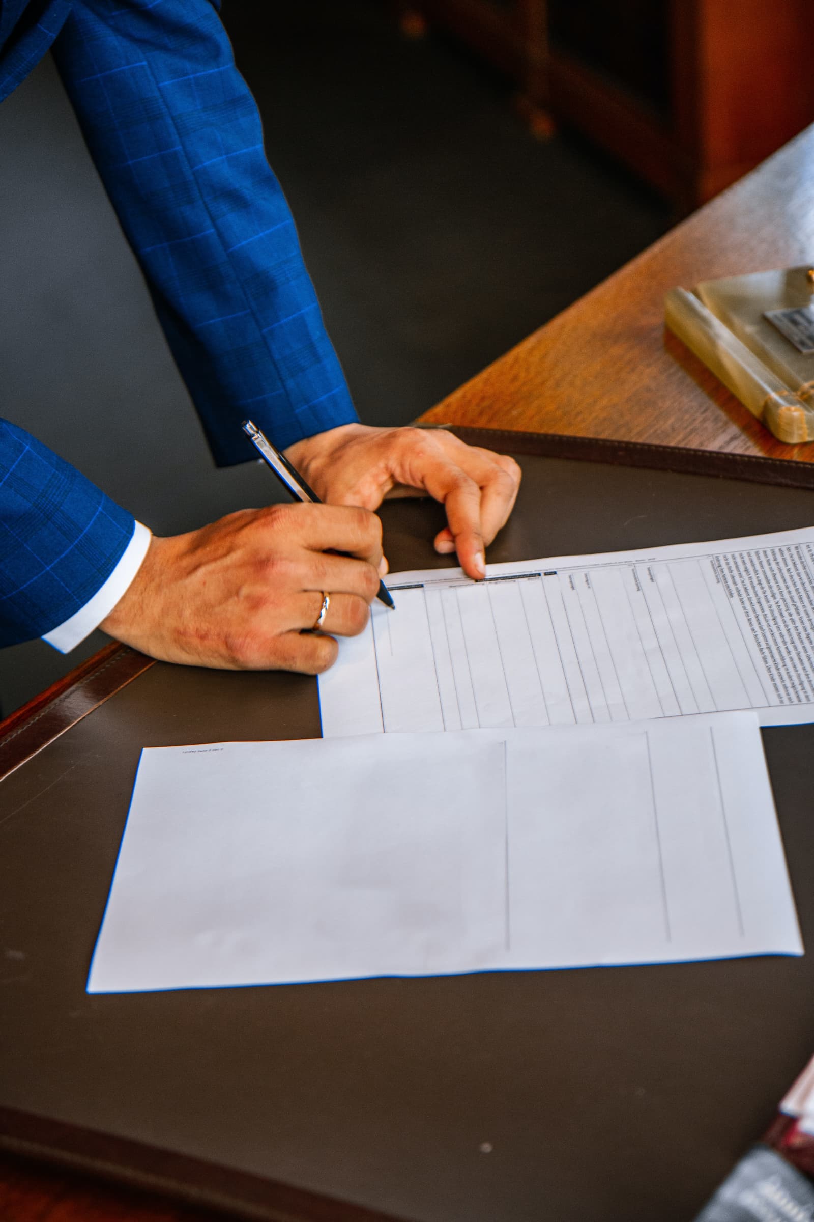 Stock photo of a man in a suit standing over a contract