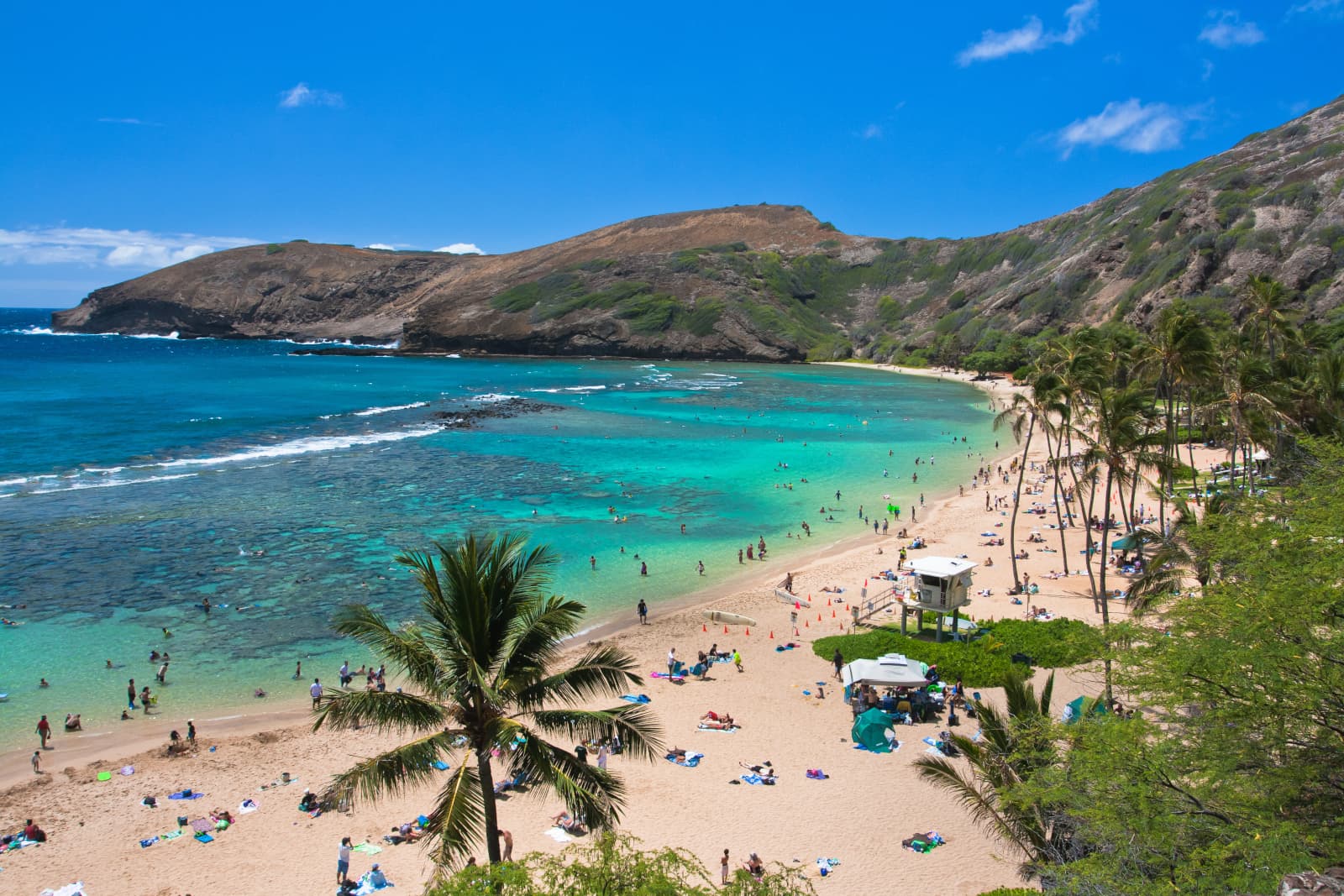 A beautiful bay with people on the beach and in the shallows, 