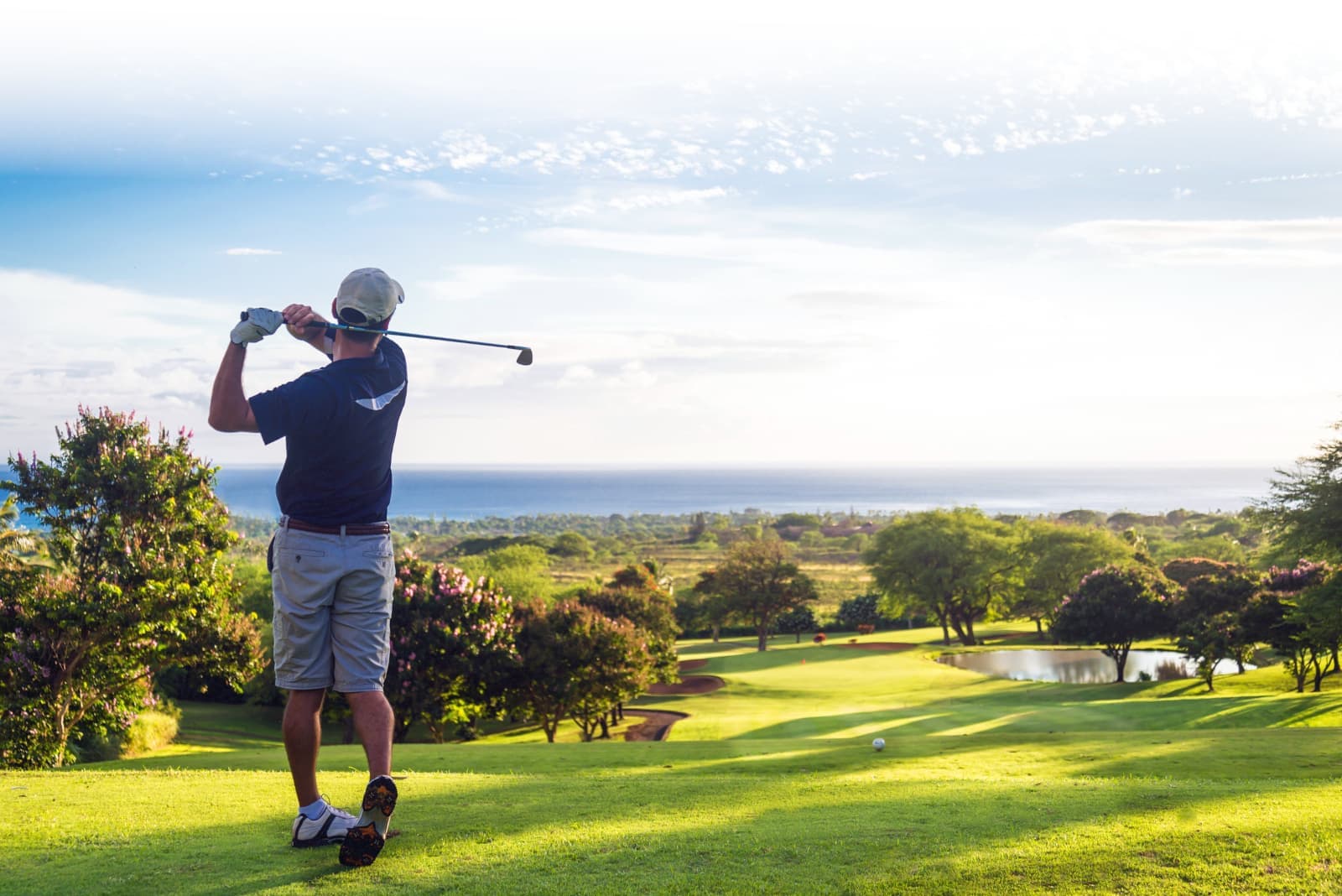 Green golf course with someone in the middle of their backswing