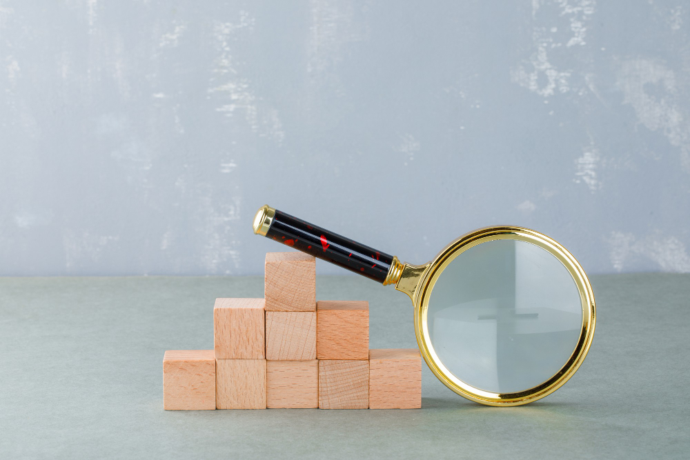 Searching and business concept with wooden blocks, magnifying glass side view.