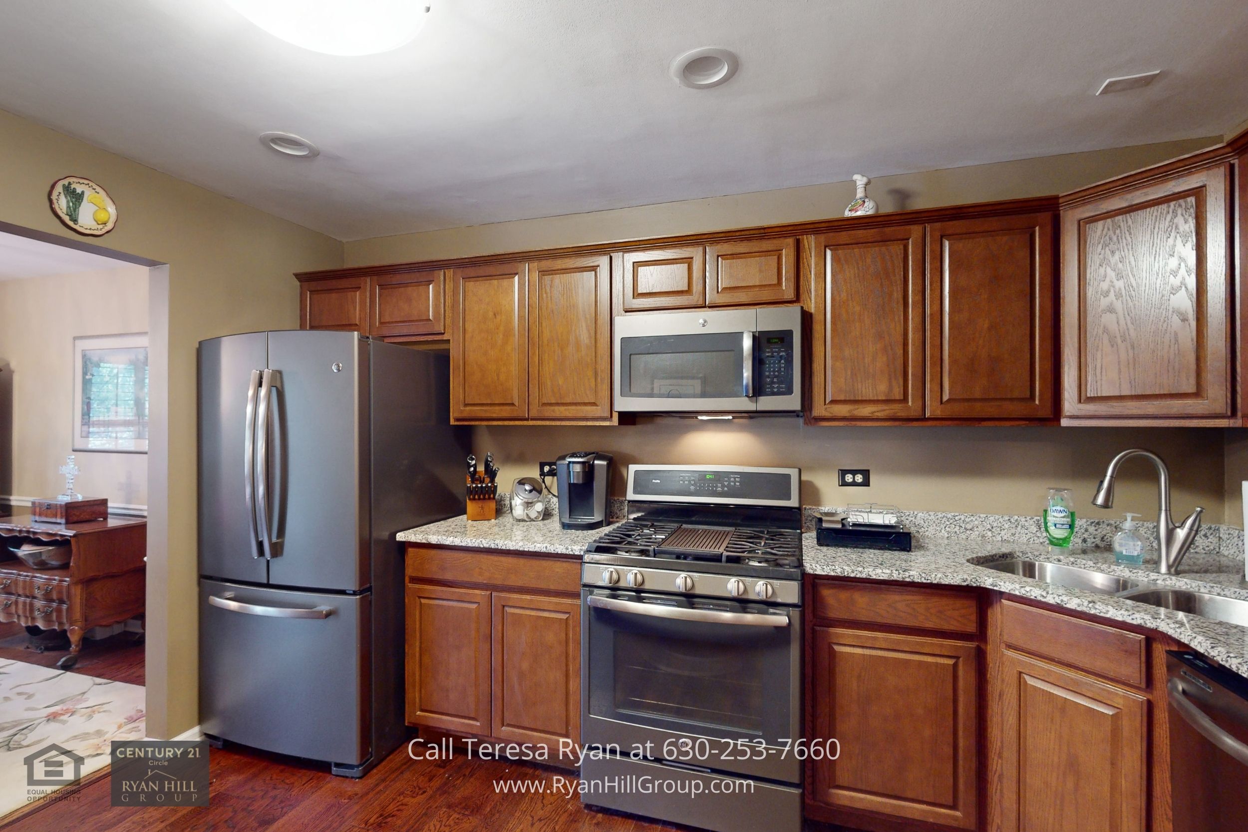 This lovely townhome in Winfield IL has a gourmet kitchen has GE stainless steel appliances, a gas cooktop with five burners, and a stainless double sink all beautifully captured in this photo.
