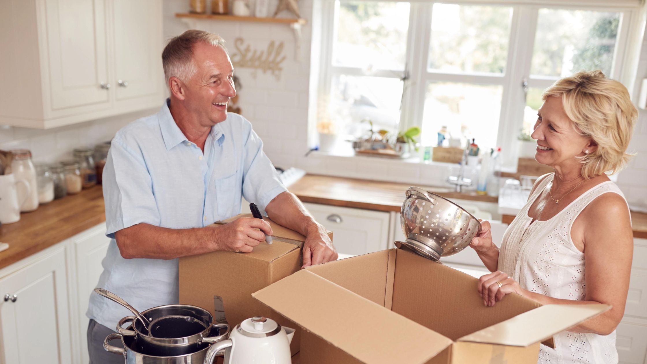 A senior couple smiles as they admire their new, smaller suburban home after downsizing in Naperville.