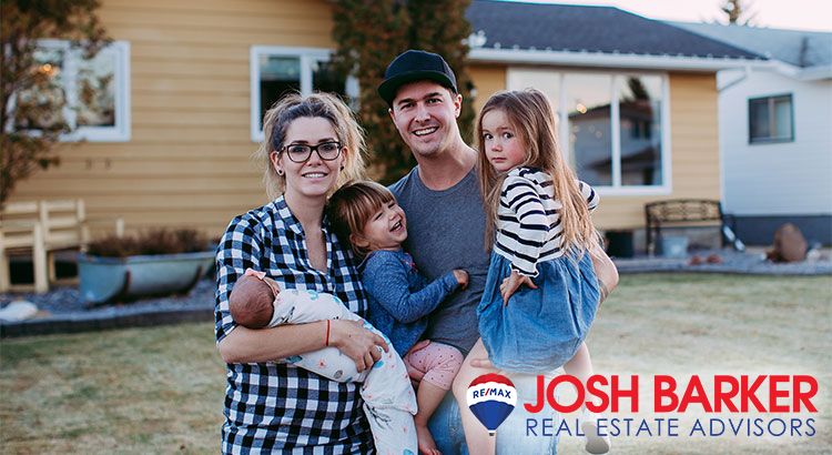 A happy family: a couple and their three children in front of their home