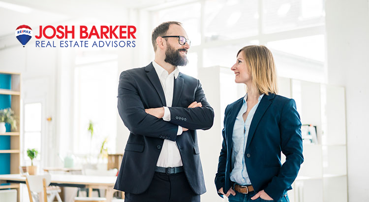 A man and a woman standing, both real estate agents.