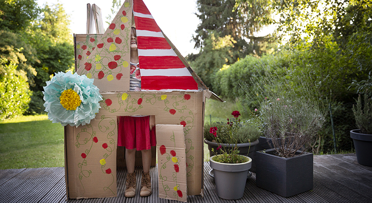 A little girl giggling in a colorful make up shift house.