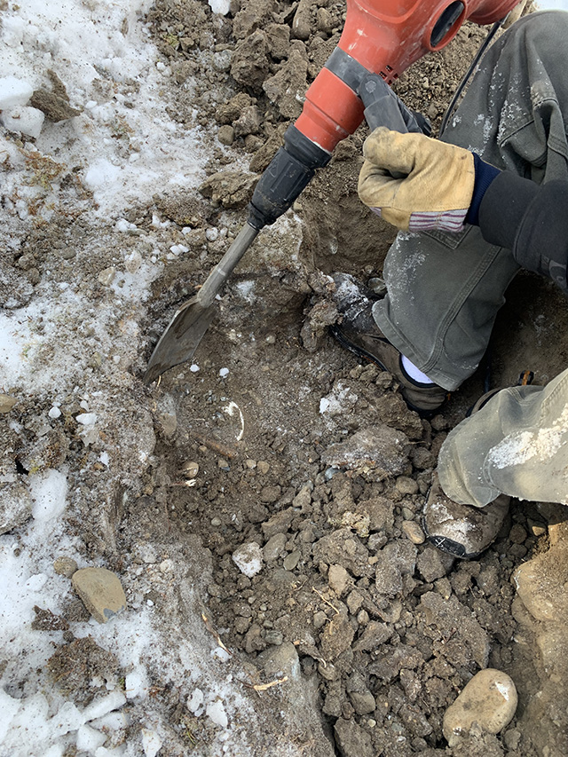 Digging through frozen ground for buried monitor tube
