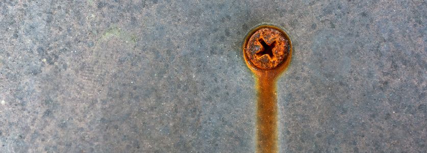 rusty screw in metal surface