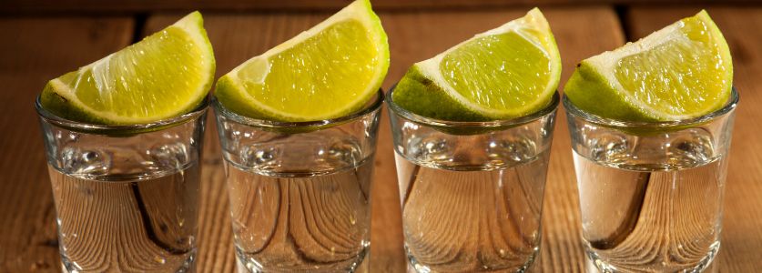 4 tequila shots with lime wedges