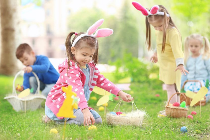easter egg hunt toddlers smiling on an outdoor easter egg hunt