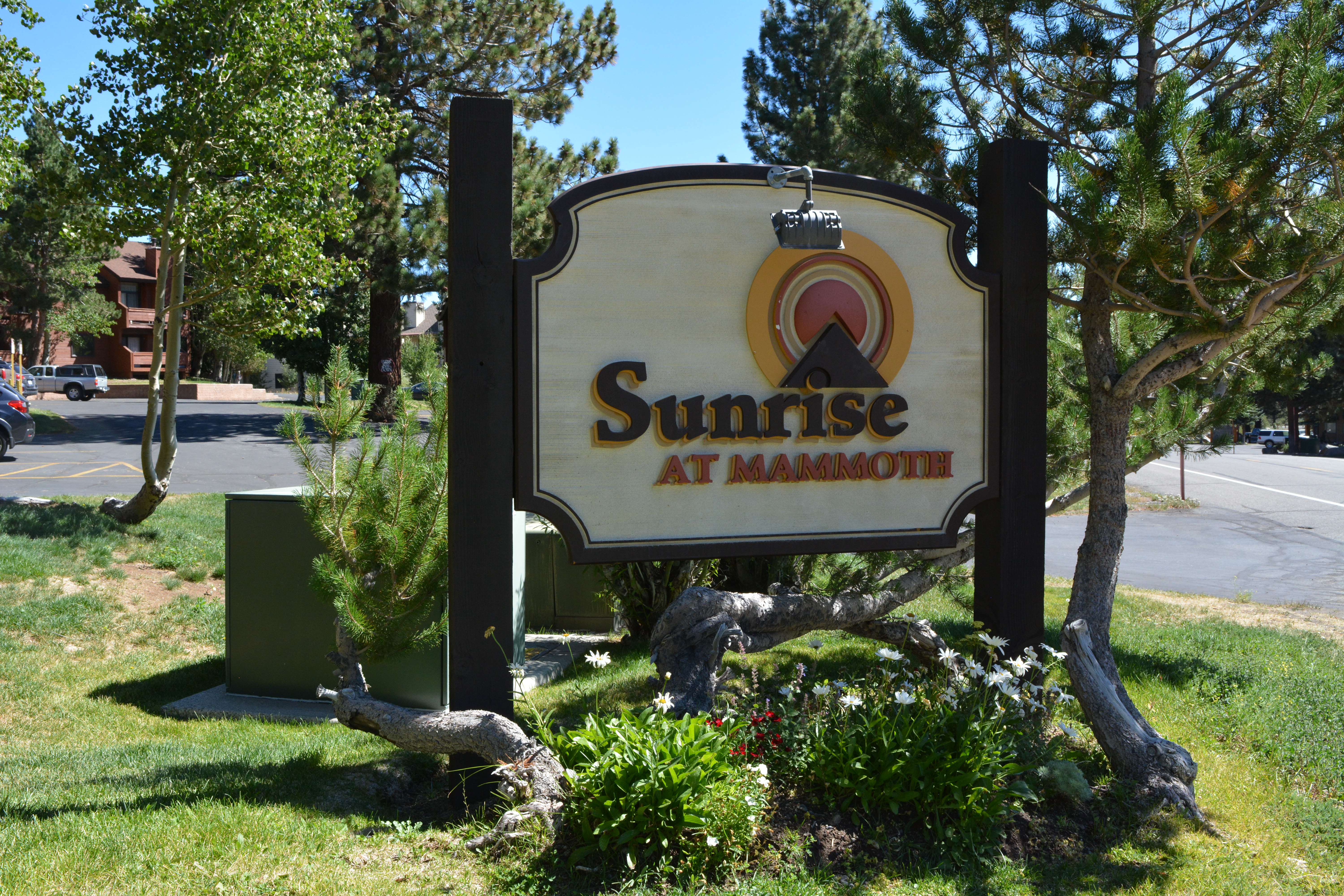Sunrise Condos Complex Sign at Entrance in Summer
