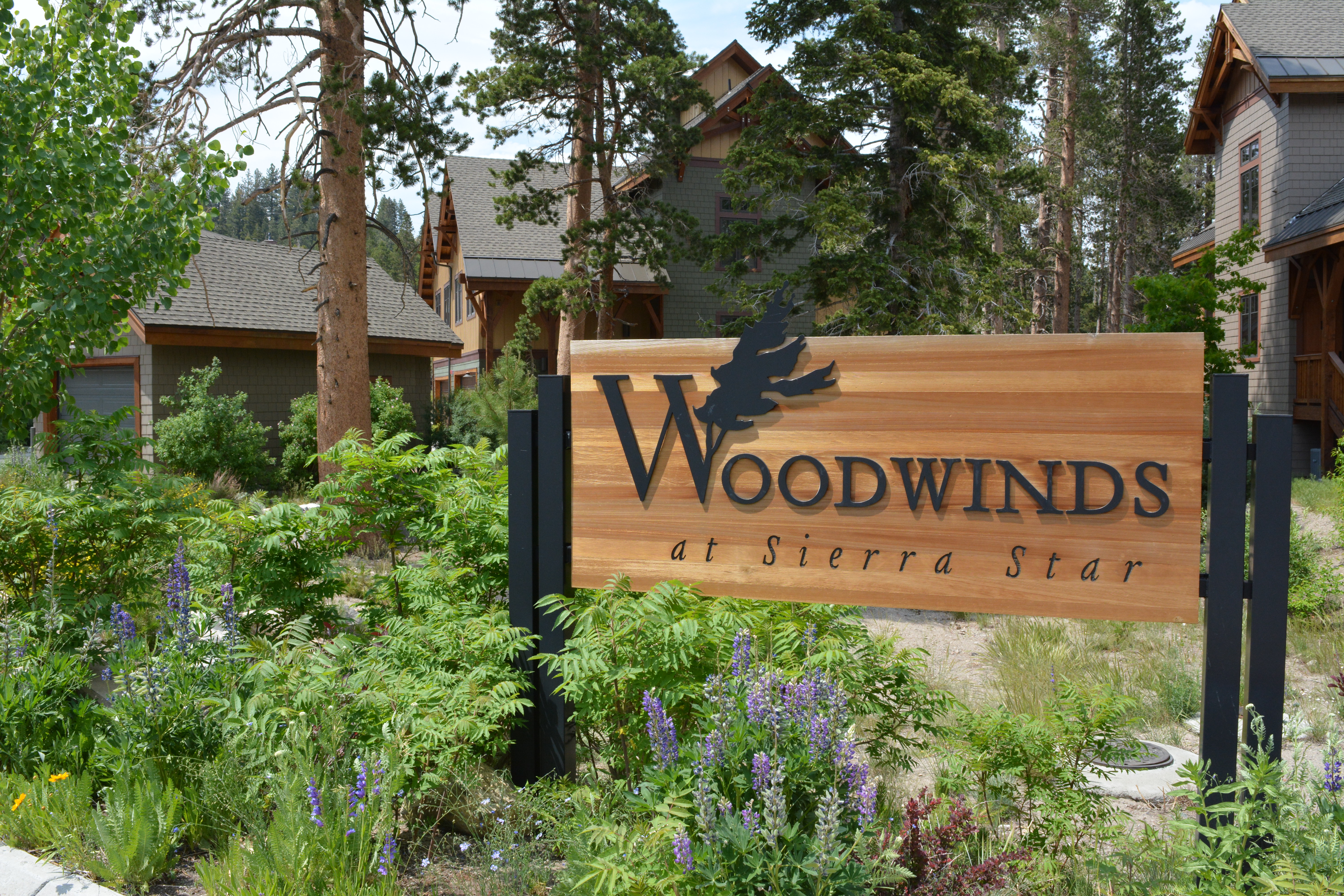 Woodwinds Condos Sign at Entrance in Summer